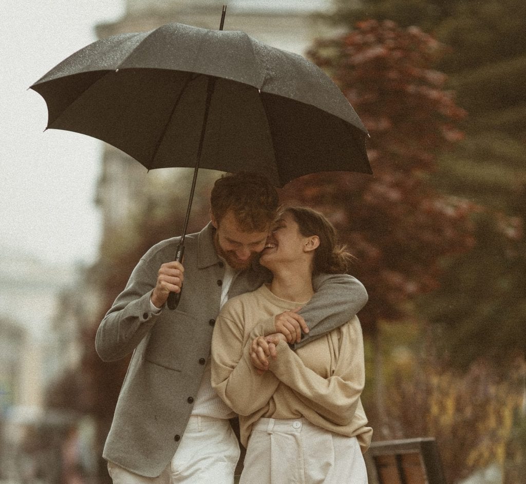 Couple under umbrella symbolizing steadiness in difficult seasons.