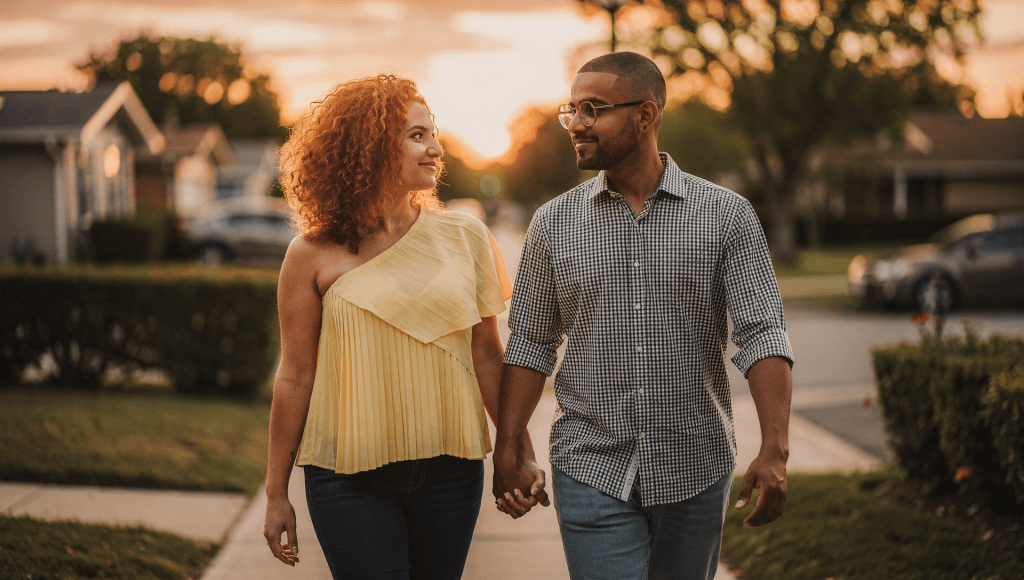 Married couple walking hand in hand at sunset, focusing on marriage in the present tense together