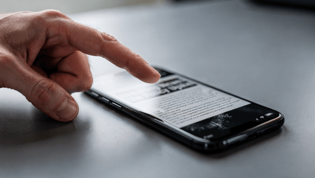 Spouse pushing a phone article toward their partner, symbolizing how repeated “helpful suggestions” can start to feel like nagging.