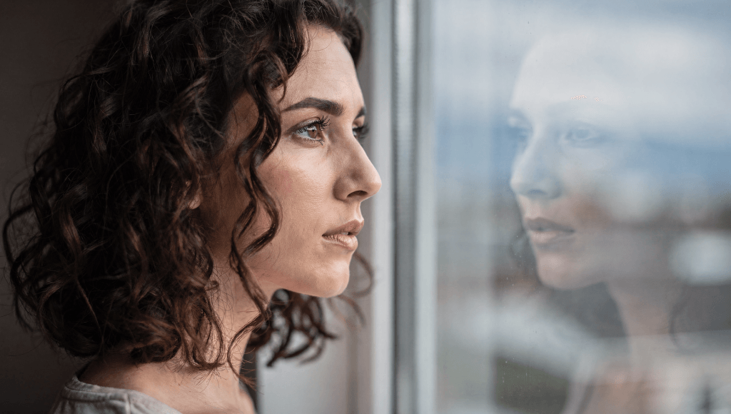 Person looking at their reflection in a window, reflecting on red flags when compliments get complicated