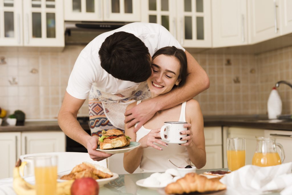 Married couple exchanging a gentle morning kiss in the kitchen, symbolizing intentional affection
