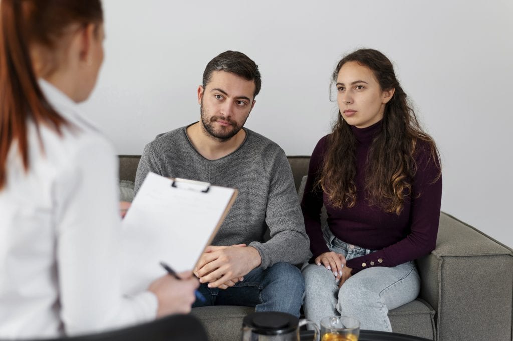 Spouses meeting with a counselor to address deeper issues that keep flaring when old triggers come back.