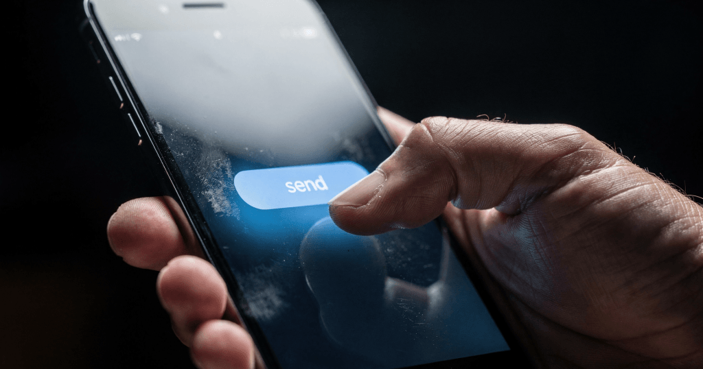 Thumb paused over a send button on a phone, symbolizing the Micro-Choices, Massive Impact pause before taking action